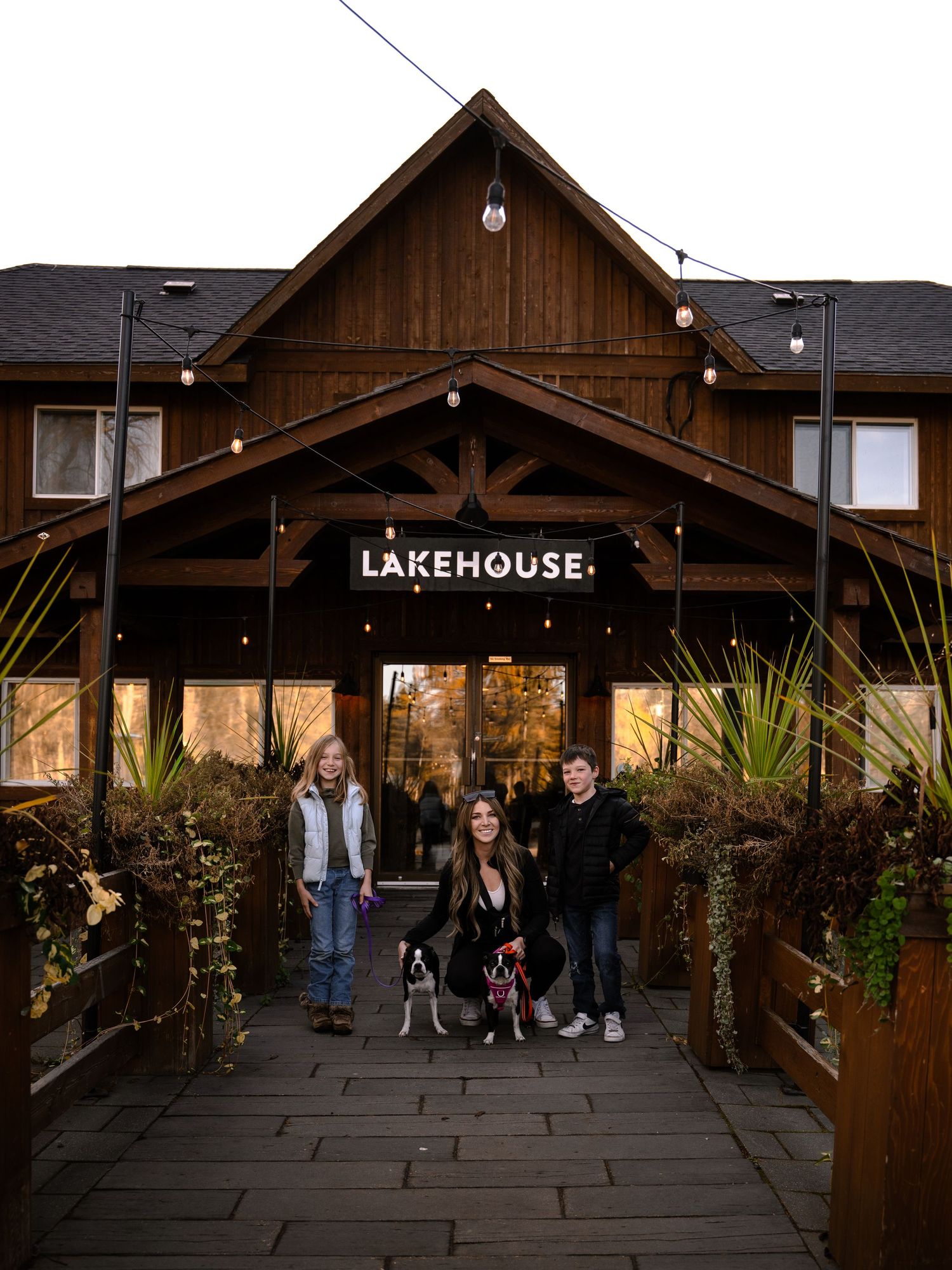 Entrance to Lakehouse restaurant with wooden archway and string lights at dusk.