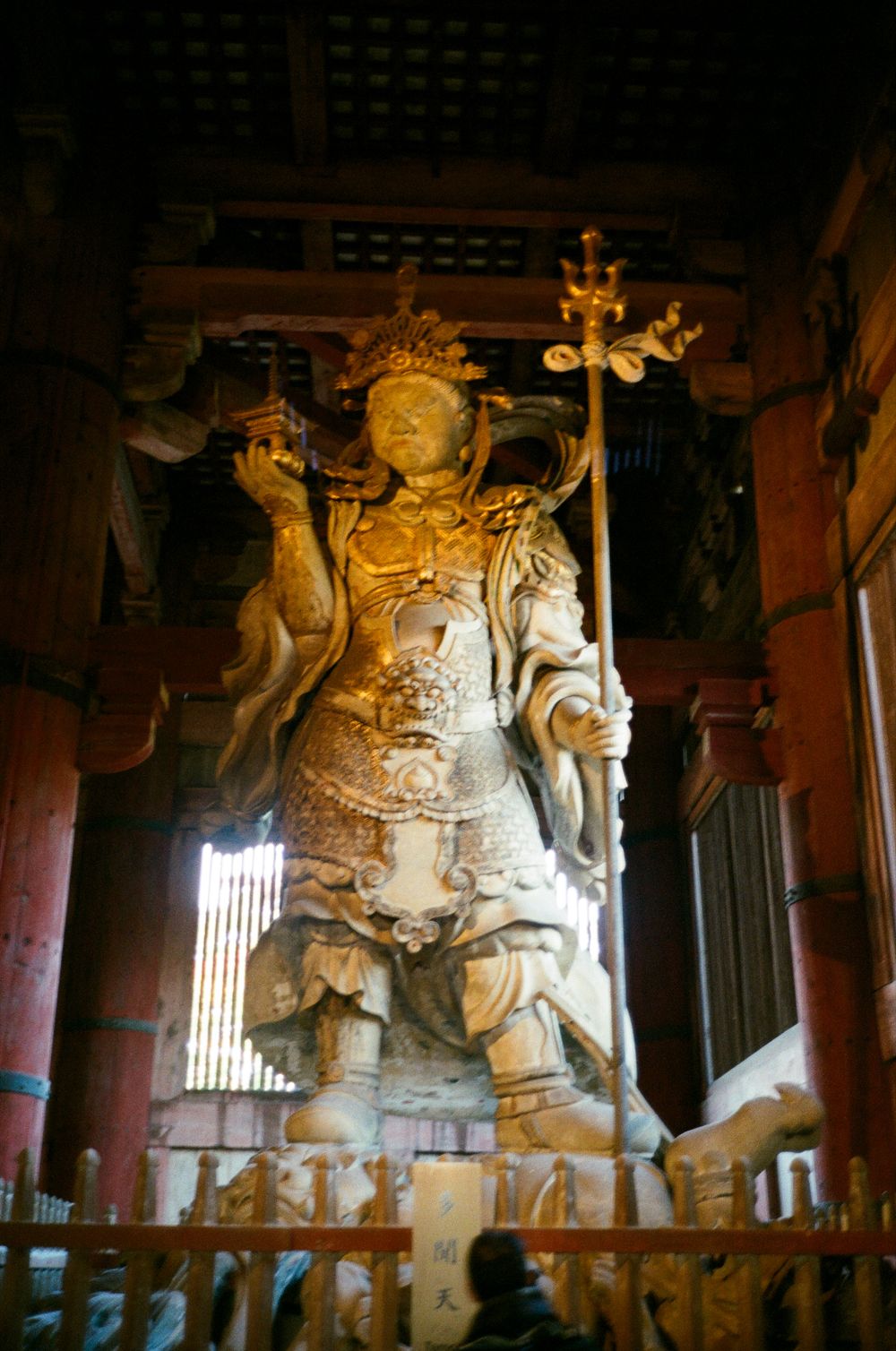 Ancient Buddhist temple statues of warrior guardians illuminated in dramatic lighting at Todaiji Temple in Nara, Japan.