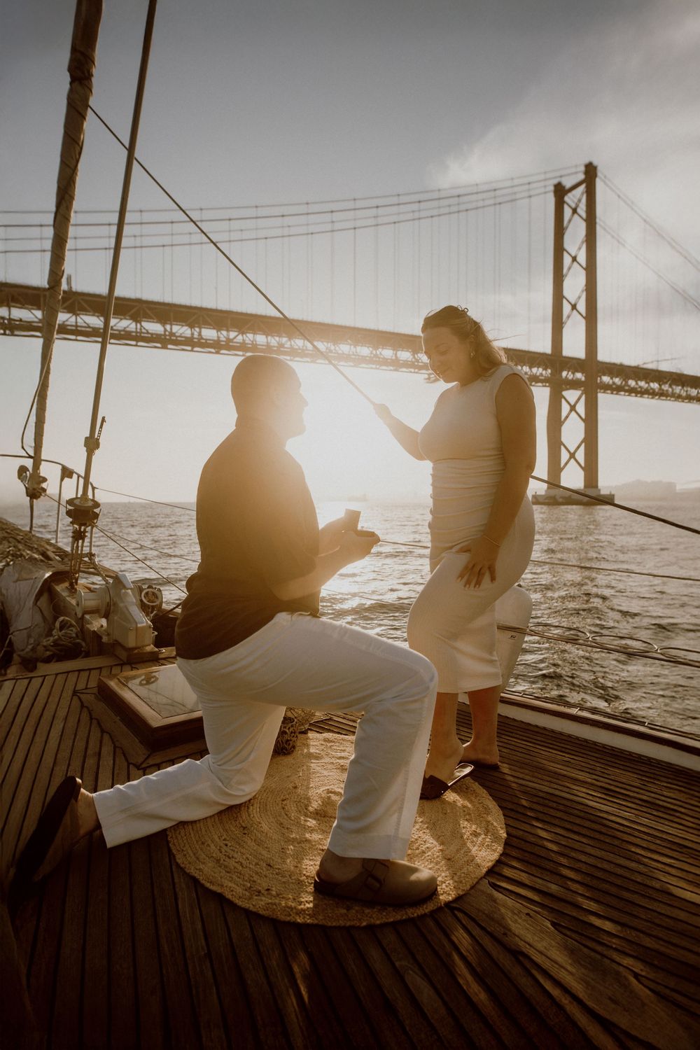 Silhouetted couple sits on wooden pier at sunset enjoying peaceful ocean view.