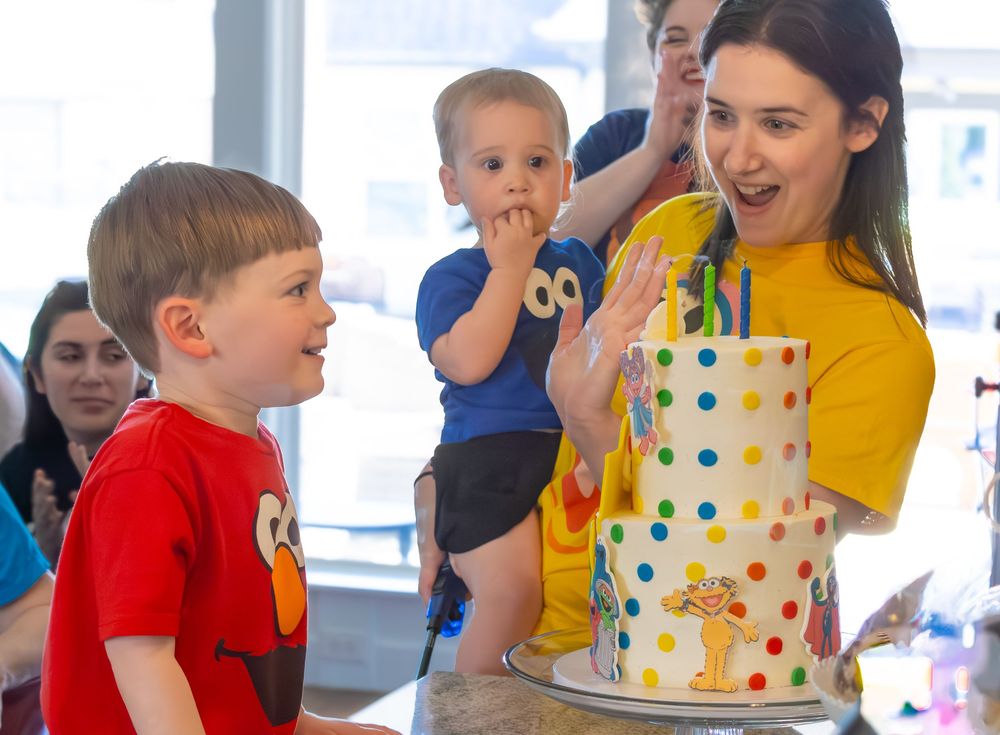 Children participate in an energetic indoor activity session with colorful polka dot decorations and bright clothing.