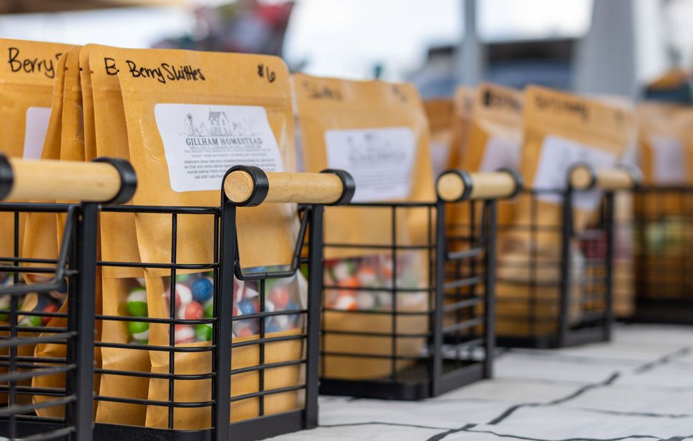 Stacks of brown paper bags and black wire baskets lined up on a wooden counter for food service preparation.