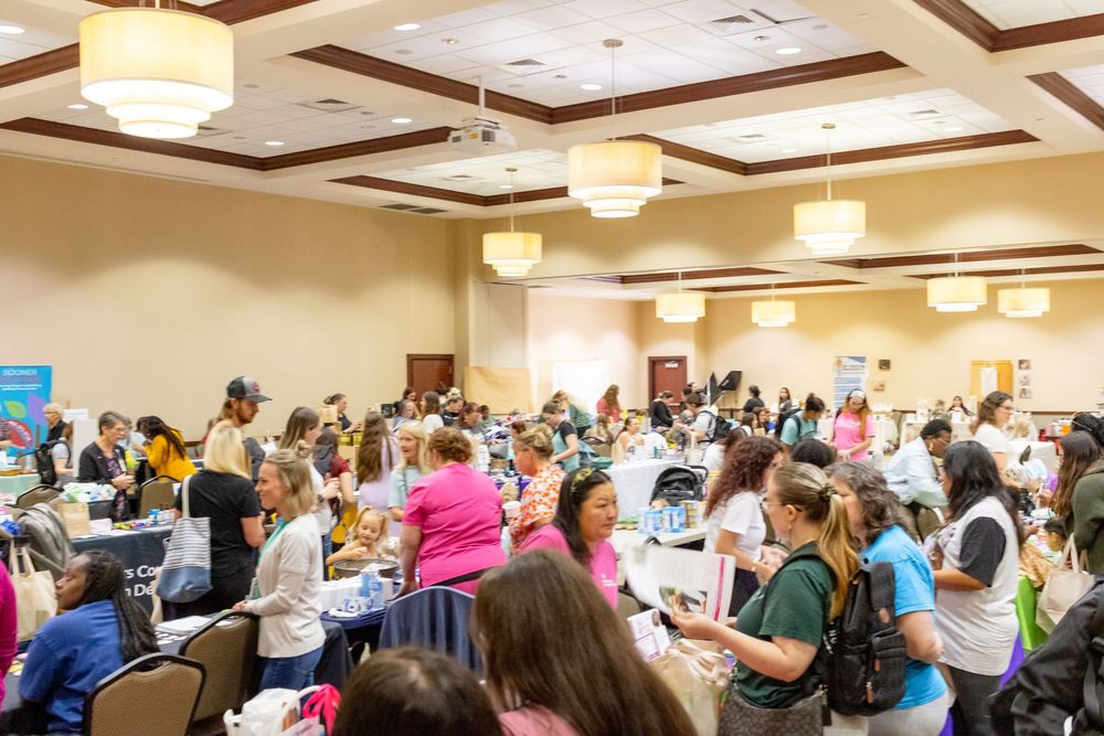 Large conference room filled with attendees seated at tables during a crowded workshop or training event.