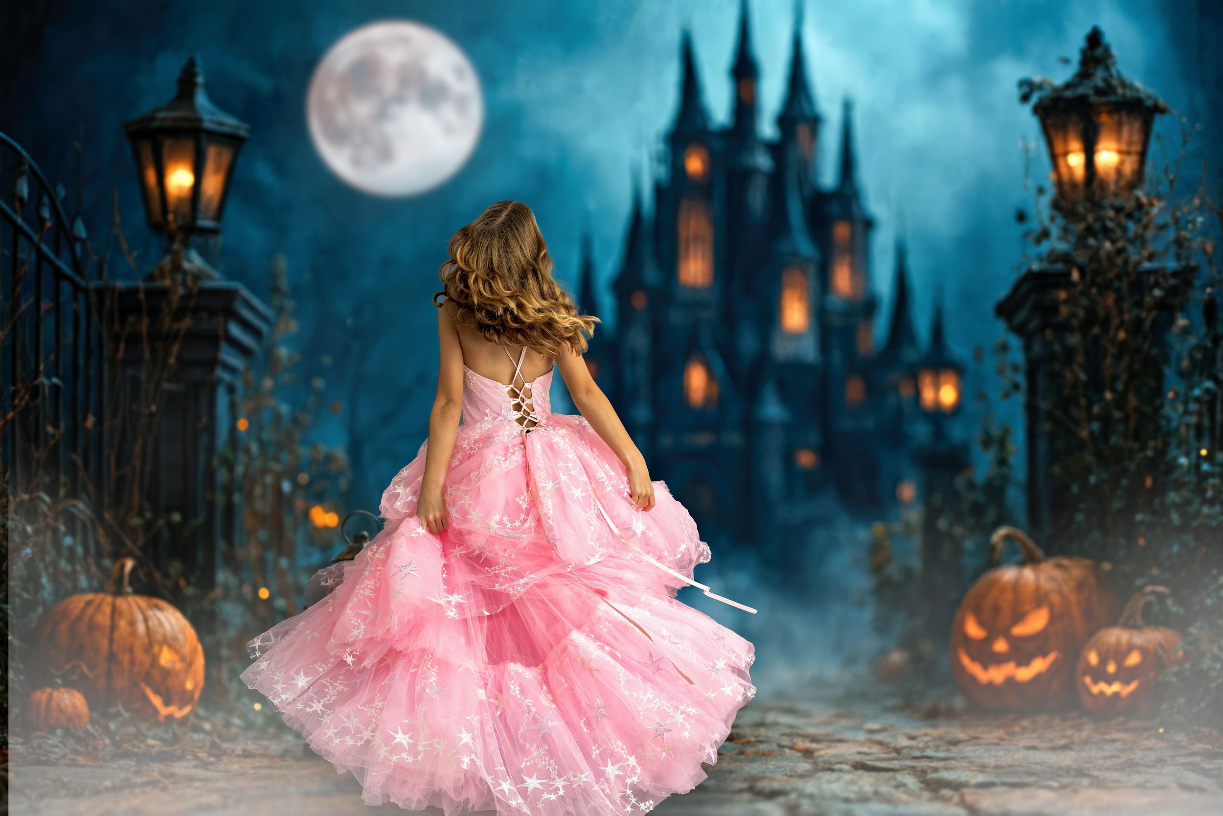 A girl spinning in a pink couture gown in front of a Halloween decorated castle