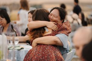 Heartfelt moments and embraces shared between wedding attendees at outdoor celebration.