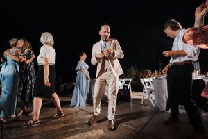 Wedding guests dancing and celebrating on an outdoor dance floor at night.