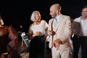 Couple shares an intimate dance moment under dramatic lighting at evening reception.