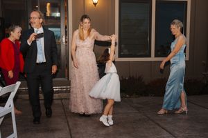 Wedding guests dancing together on a dimly lit dance floor during an evening celebration.
