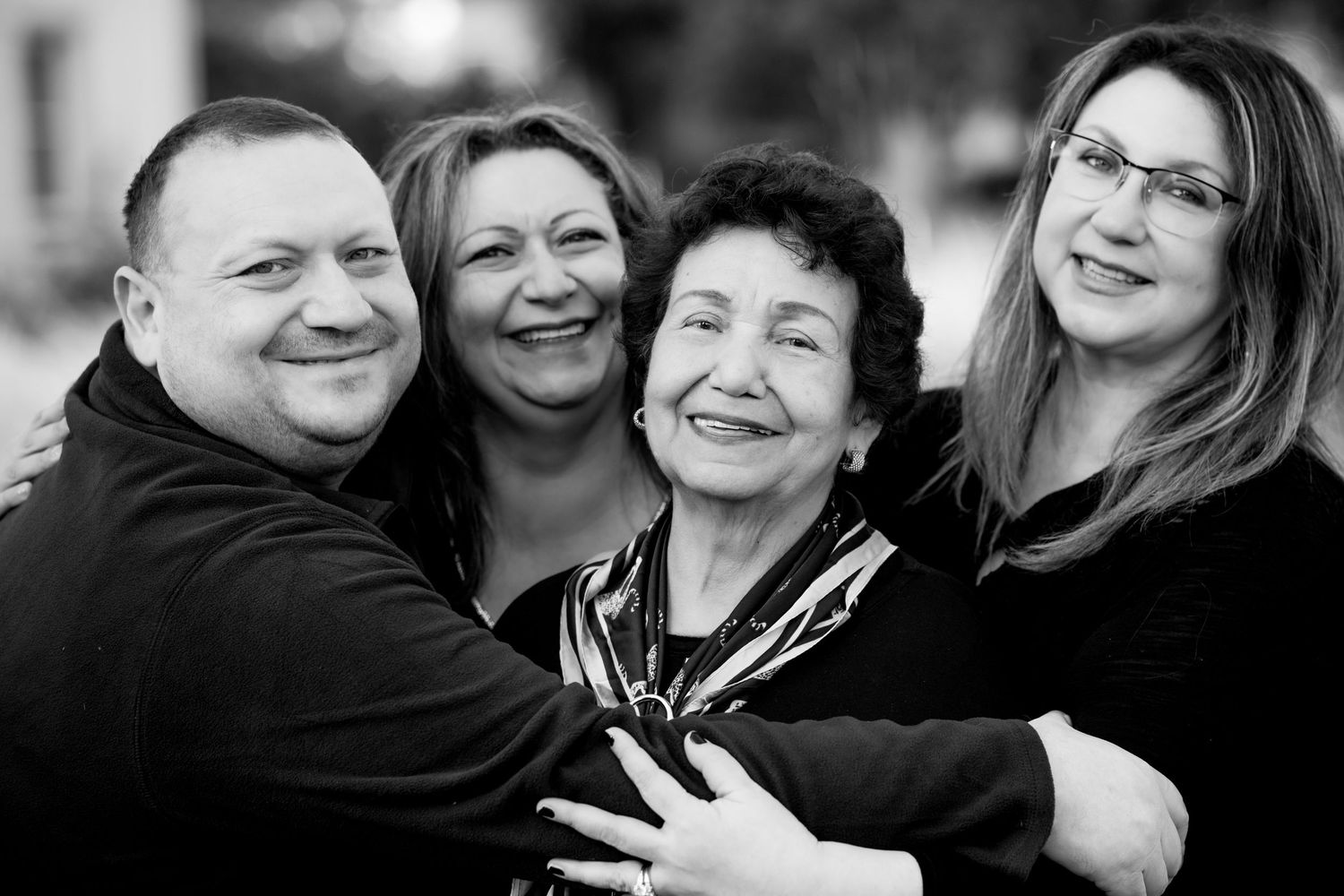 A black and white collage of candid group photos showing joyful expressions and embraces.