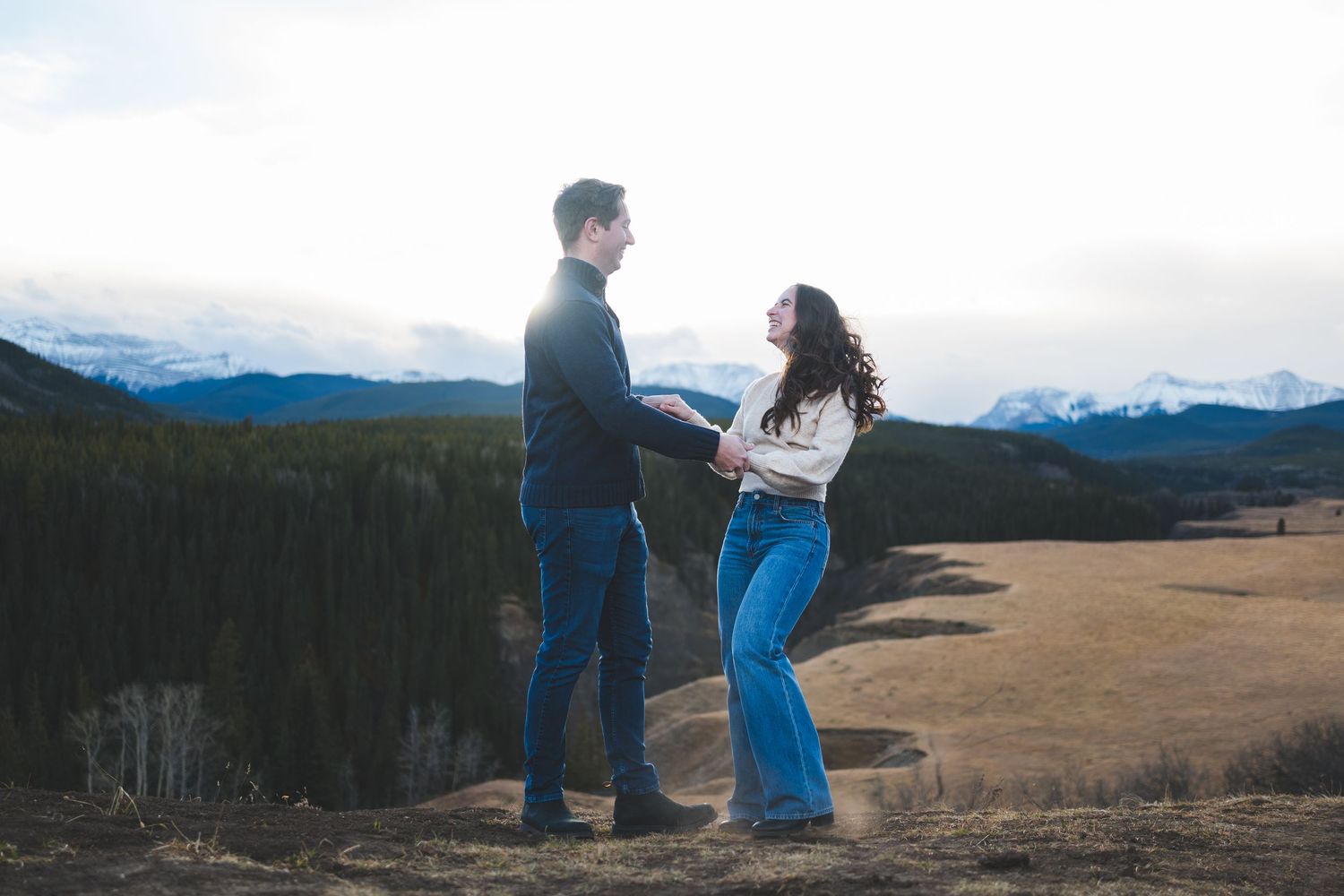 Panoramic mountain landscape serves as backdrop for romantic couple photos.