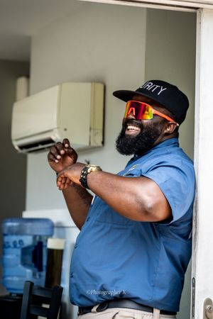 Security guard in blue uniform and cap aims handgun during tactical training exercise.
