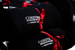 Black luxury gift box tied with elegant red satin ribbon against dark background.