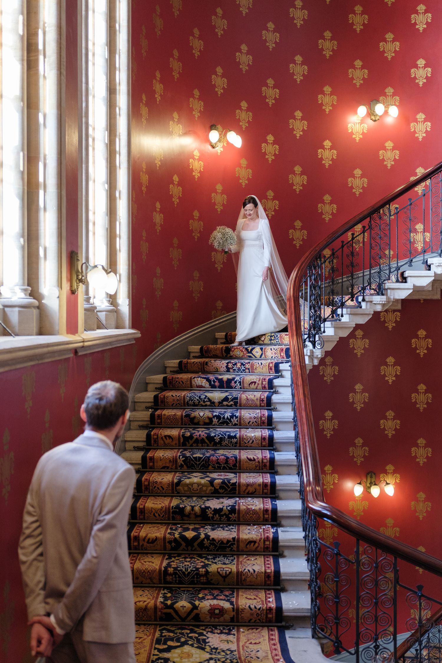 A sequence of photos showing a bride ascending an elegant red-wallpapered staircase with ornate gold patterns.