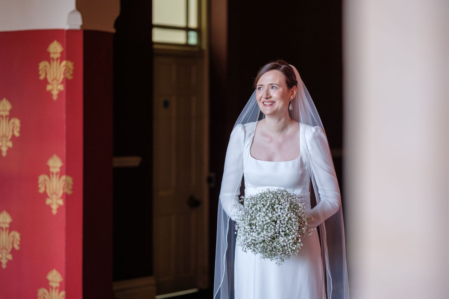 A bridal portrait in a church setting with elegant architectural details and warm lighting.