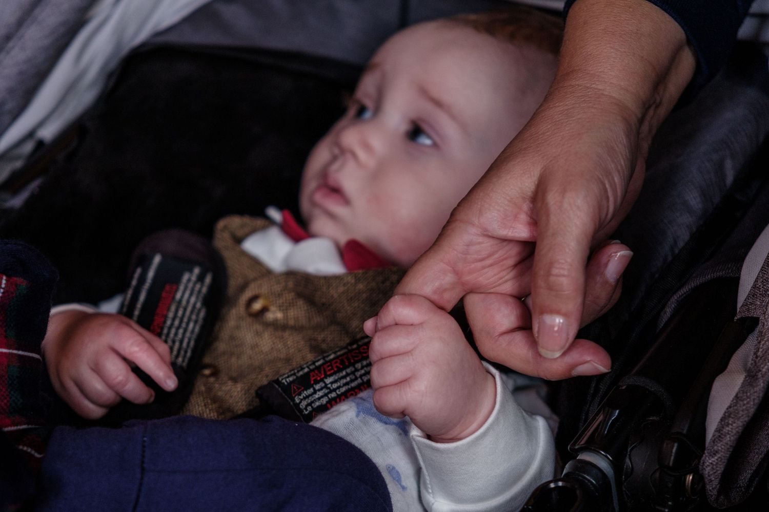 A sequence of seven photos showing a baby being fed milk from a bottle in dark lighting conditions.
