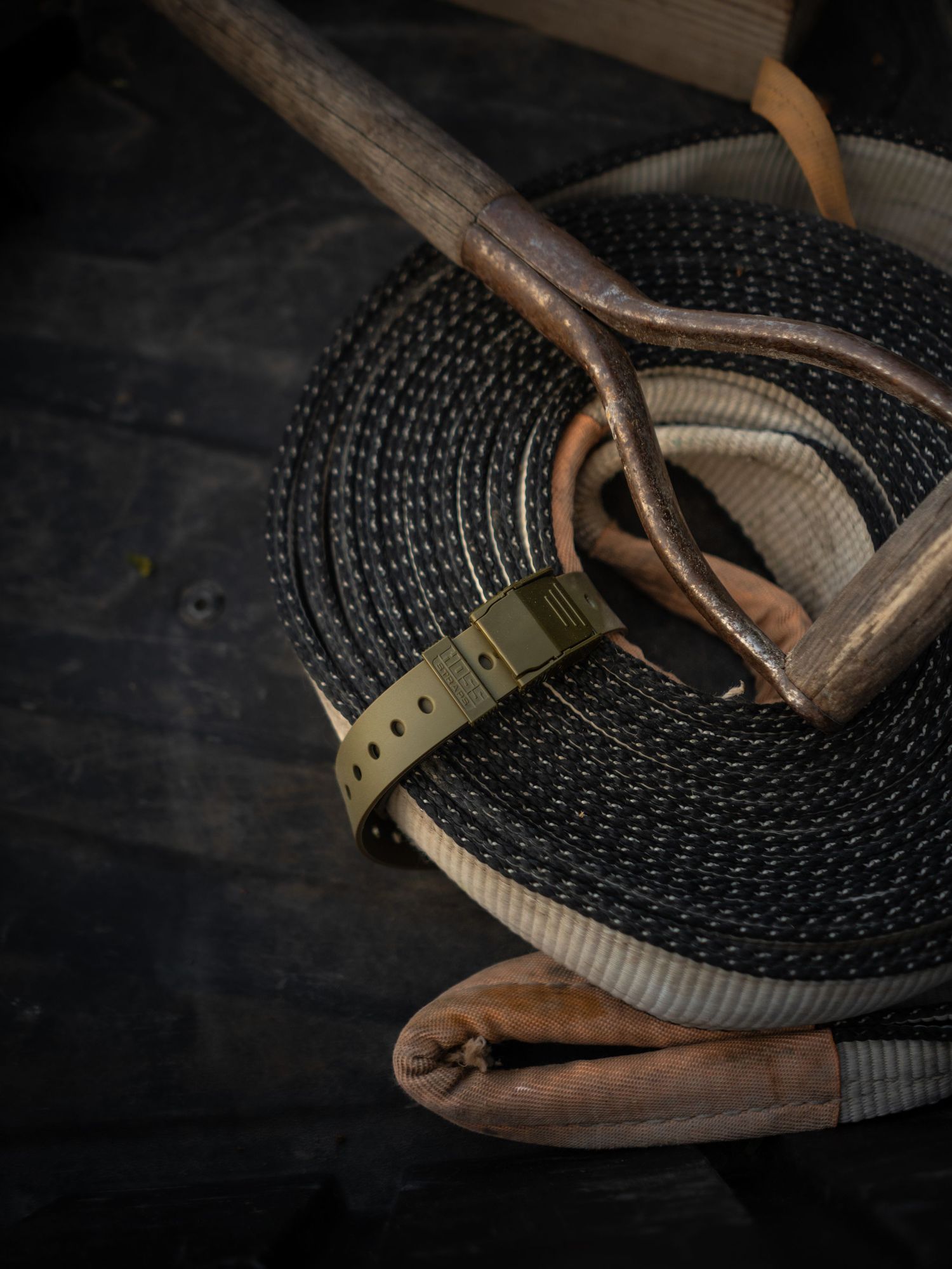 Close-up of tactical belt webbing with leather accents in moody lighting.