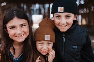 Family members share joyful moment together wearing casual winter attire.