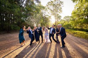 Silhouettes of people walking together on a dirt path at sunset creating long shadows on the ground.