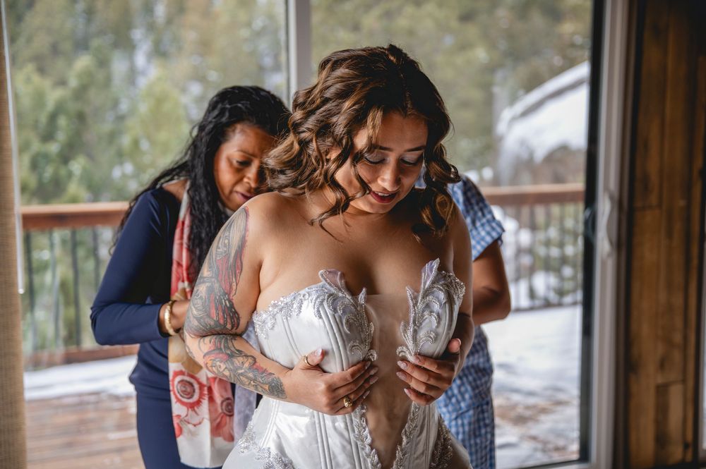 A couple embraces tenderly in a rustic wooden cabin setting with natural light streaming through windows.
