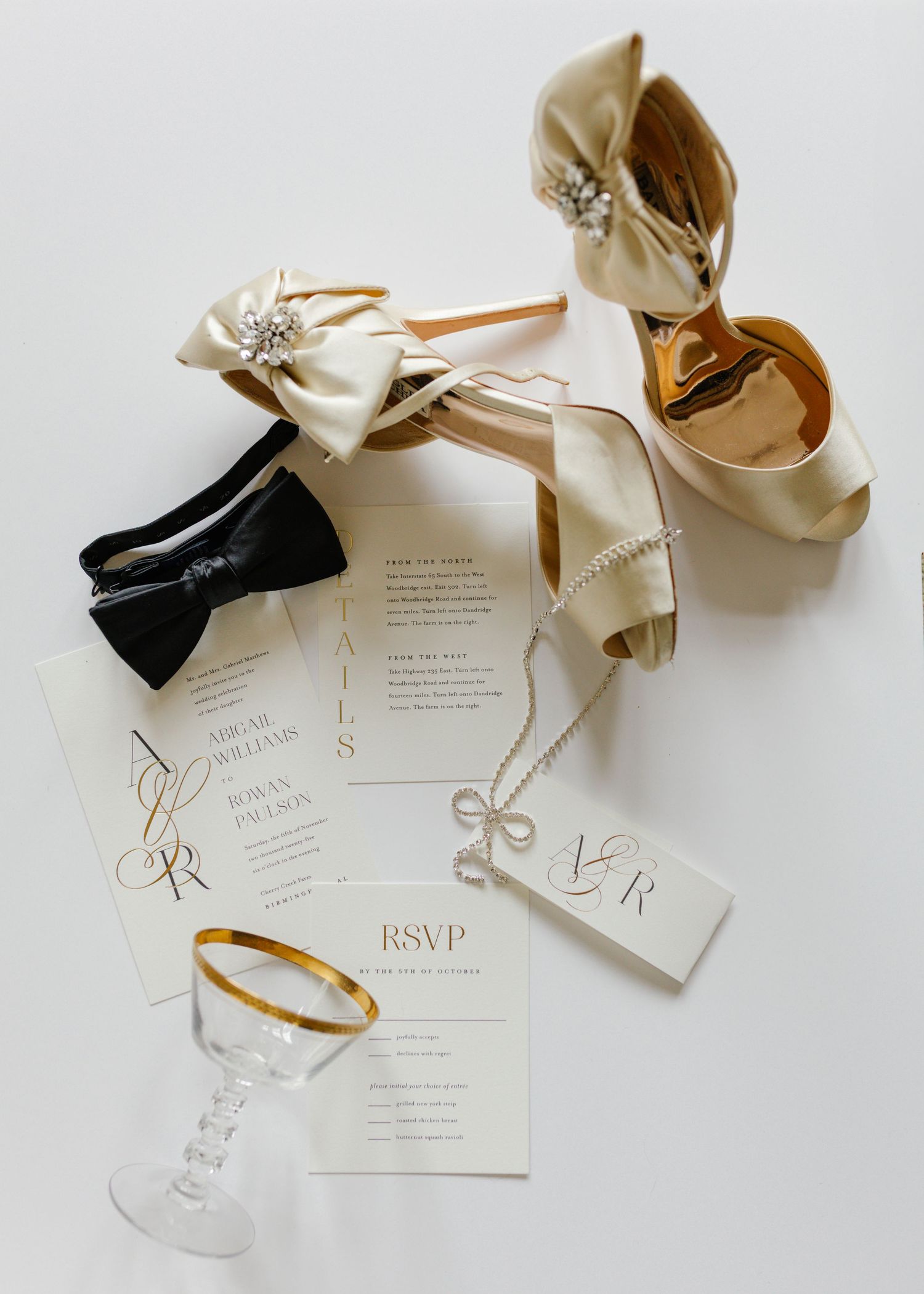 Elegant wedding invitation suite with cream paper and gold accents on white background.