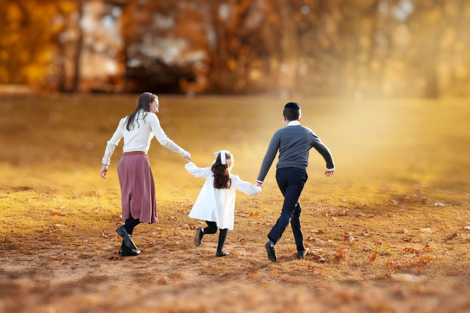 siblings running together during golden hour in the autumn