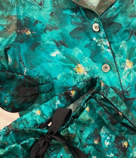 Vintage floral blouse in vibrant turquoise with abstract watercolor pattern and black bow detail.