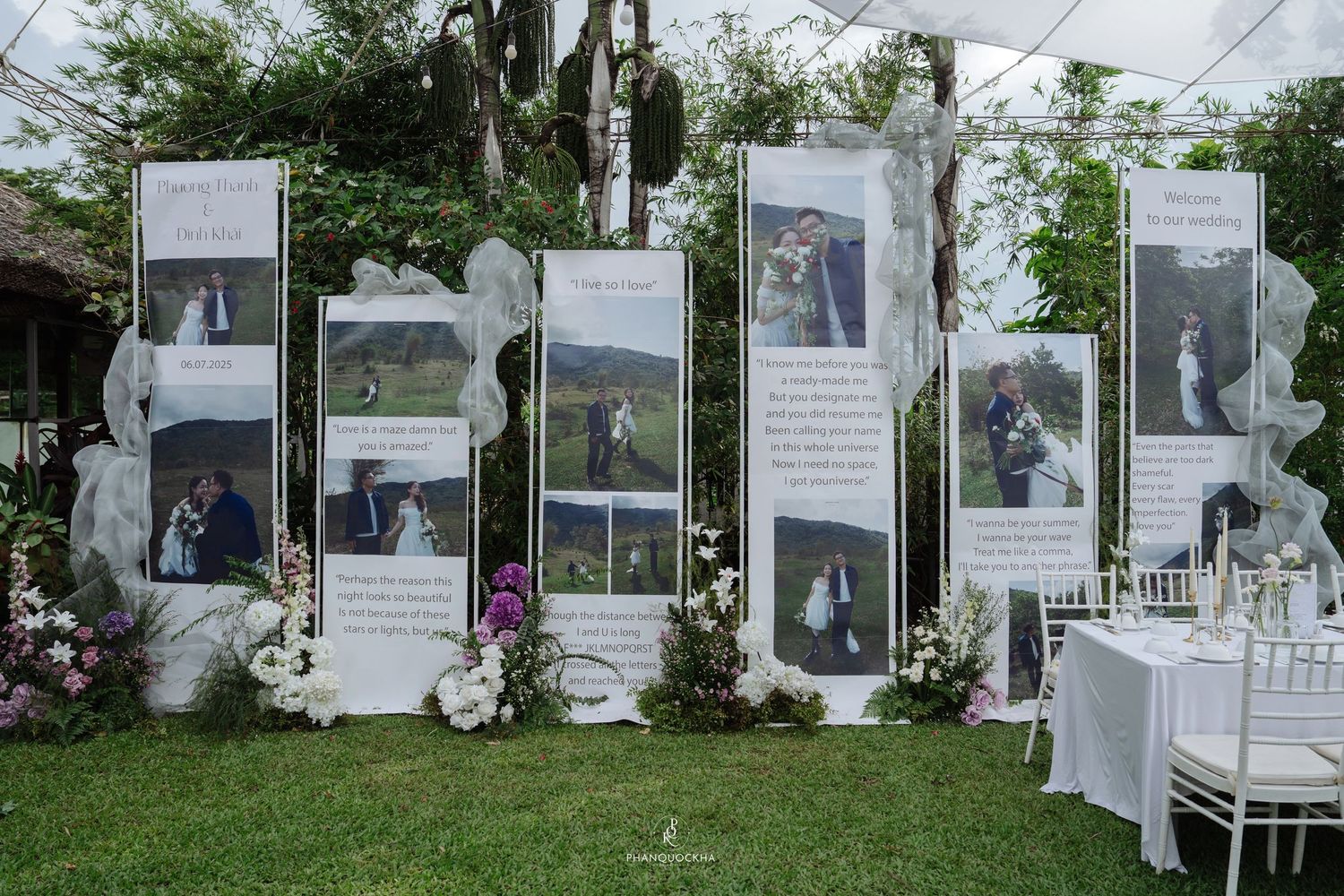Outdoor wedding display boards featuring couple photos and love story panels on green lawn.