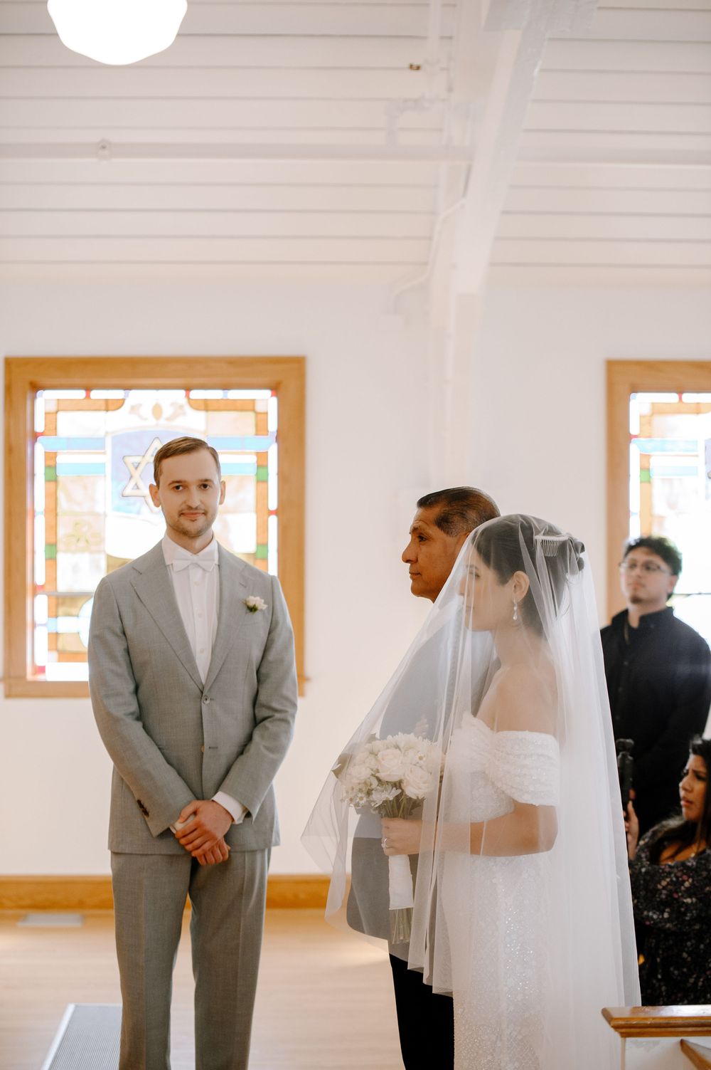 A wedding first look moment captured in sequence showing the couple meeting in a bright indoor setting.
