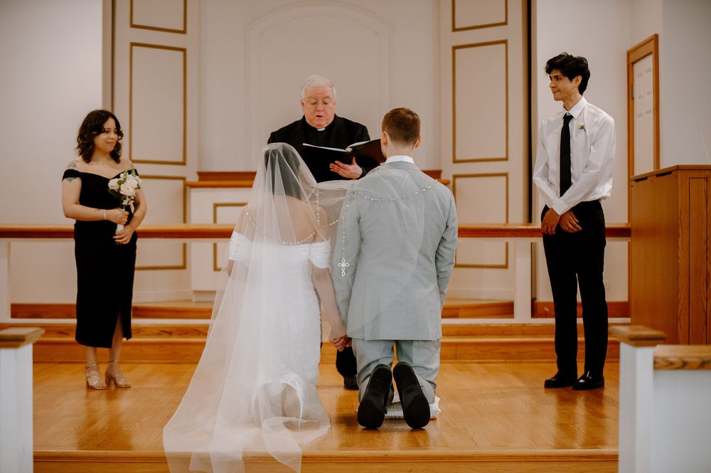 Wedding ceremony in a bright indoor venue with classic white and gold architectural details.