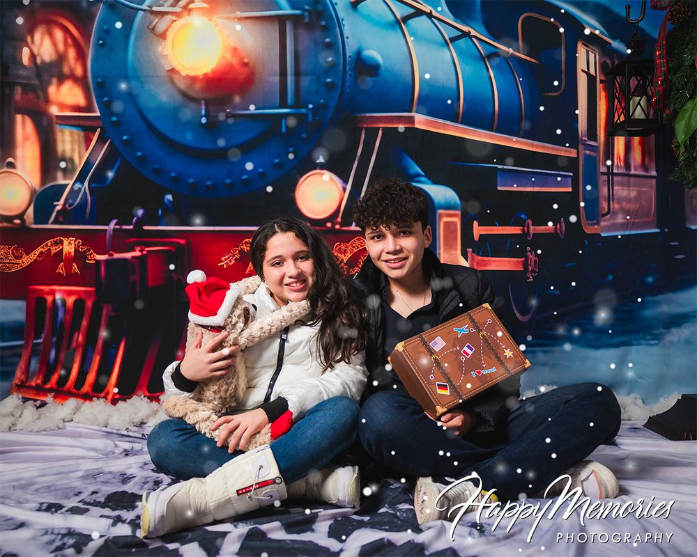 Winter themed photo shoot with vintage train station backdrop and falling snow effects.