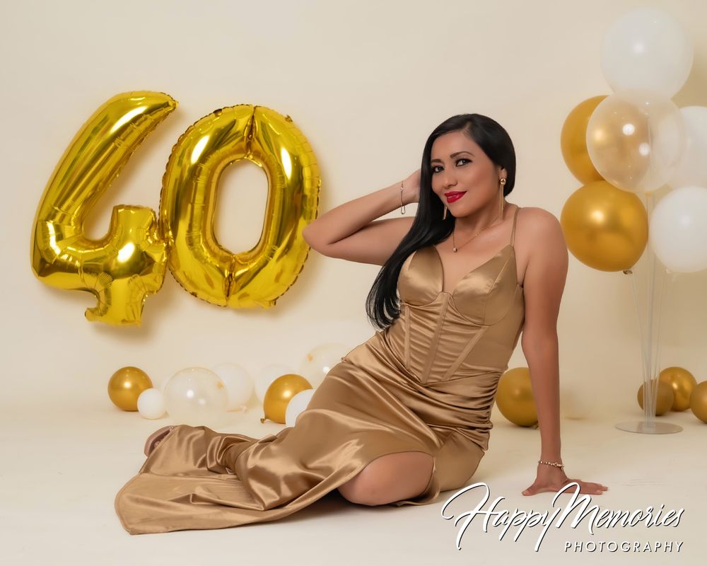 Birthday celebration photoshoot with gold number balloons and champagne-colored dress.