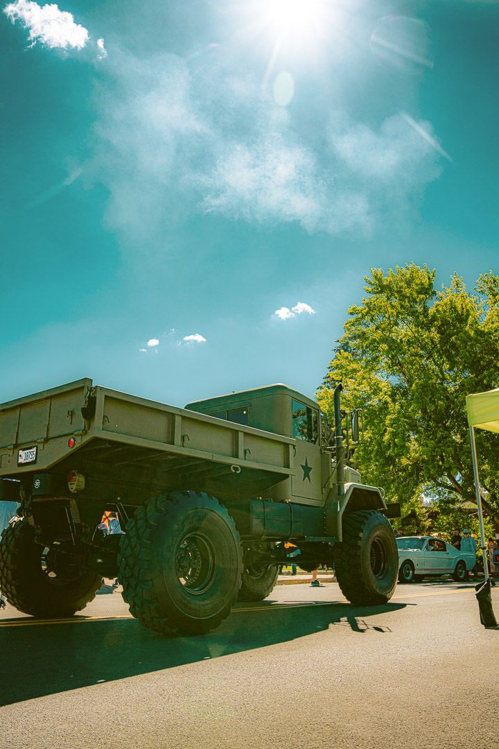 Overlapping images of a low-angle view of a military truck chassis against a turquoise sky on a sunny day.