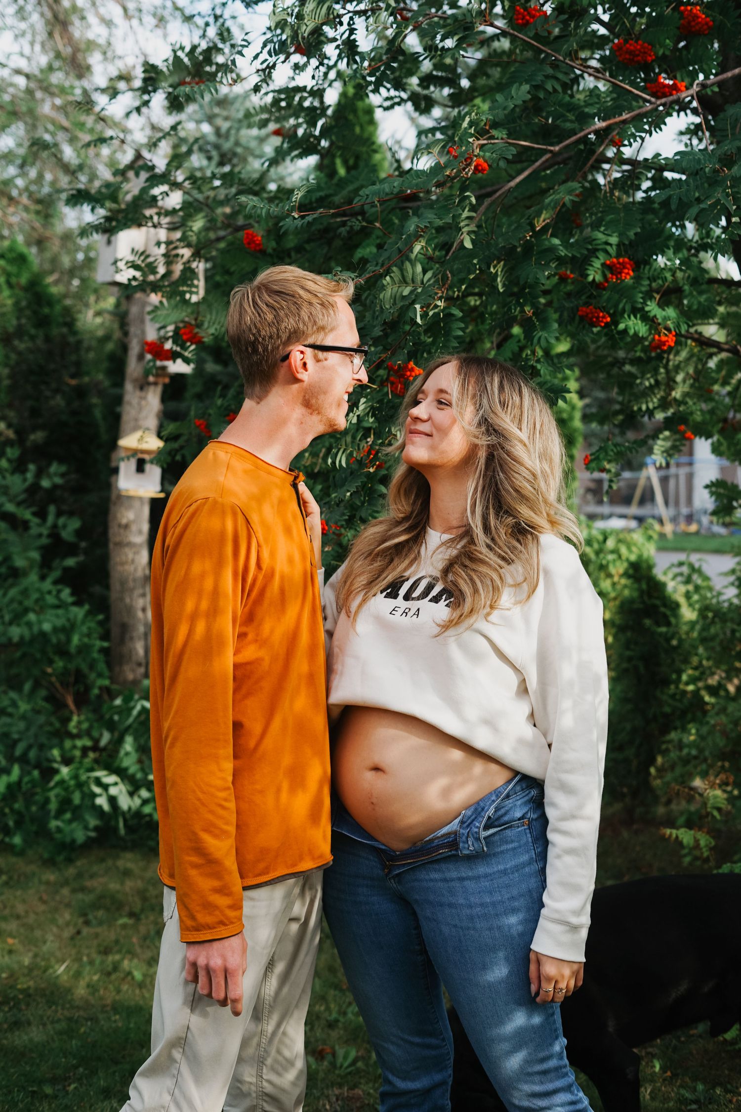 A couple enjoying a sunny autumn day together while walking in a garden with trees and golden light.