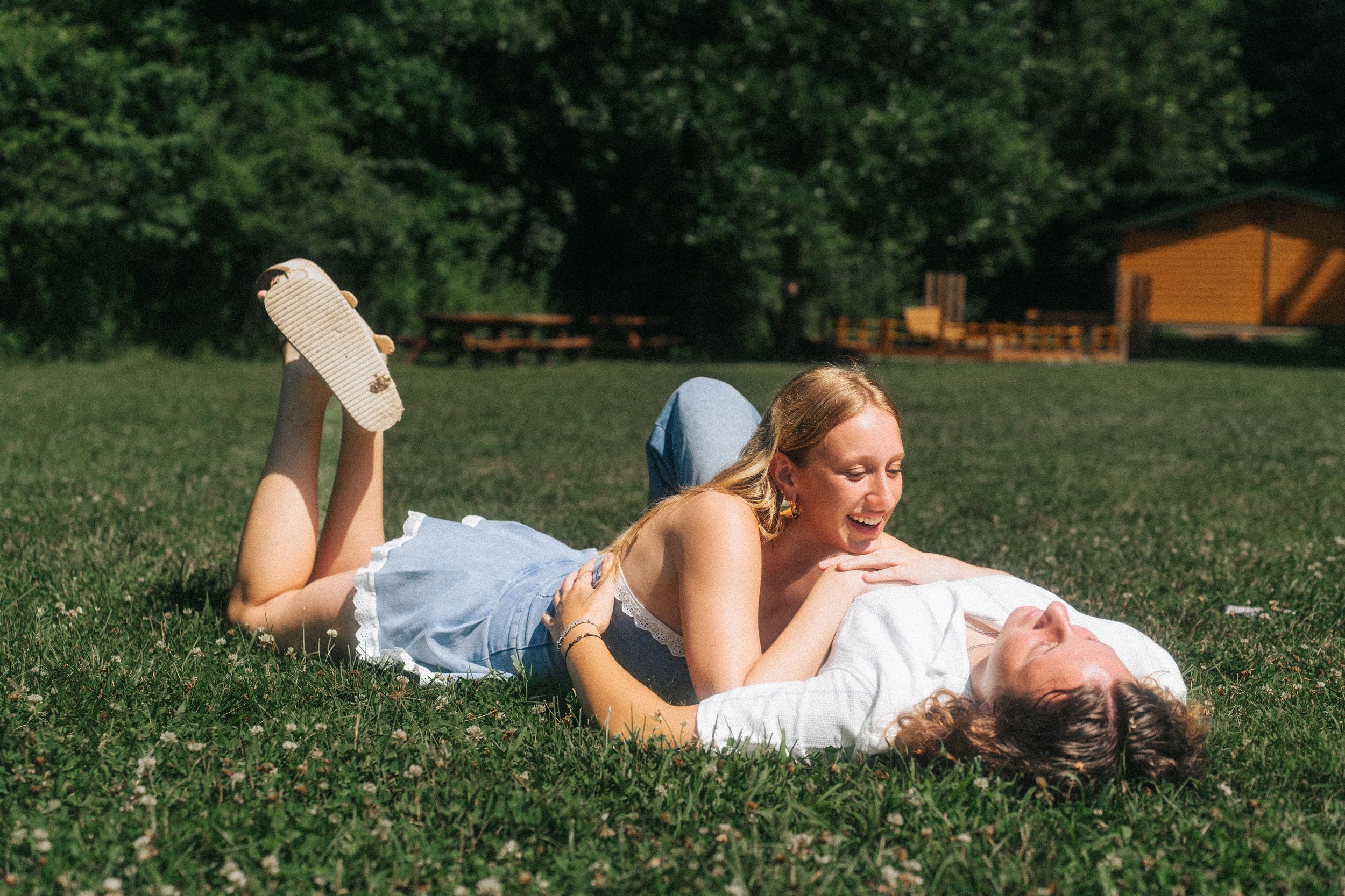 Couple relaxing together on green grass during summer day.