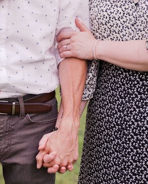 Close-up shots of couple holding hands showing details of their floral and casual attire.