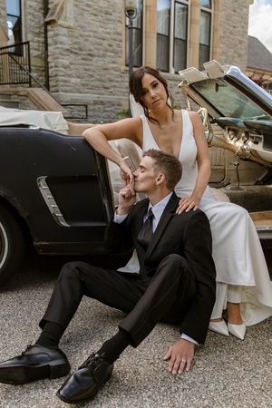 Stylish wedding photo near vintage black car with artistic composition.