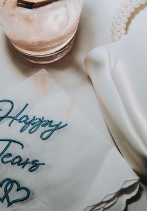 Close-up view of handwritten text on white paper with soft lighting and blurred glass containers in the background.
