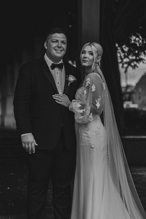 Black and white wedding photos showing intimate moments between newlyweds in formal attire.