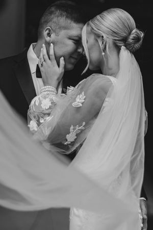 Artistic black and white wedding portraits capturing tender moments with flowing veil details.