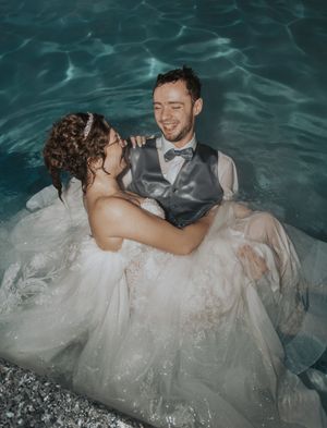 Romantic underwater wedding photo shoot with flowing white dress in pool.