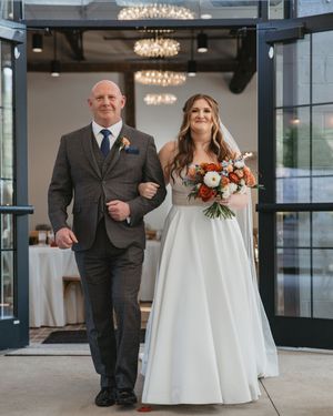Elegant wedding ceremony setup in a modern venue with crystal chandeliers and floor-to-ceiling windows.