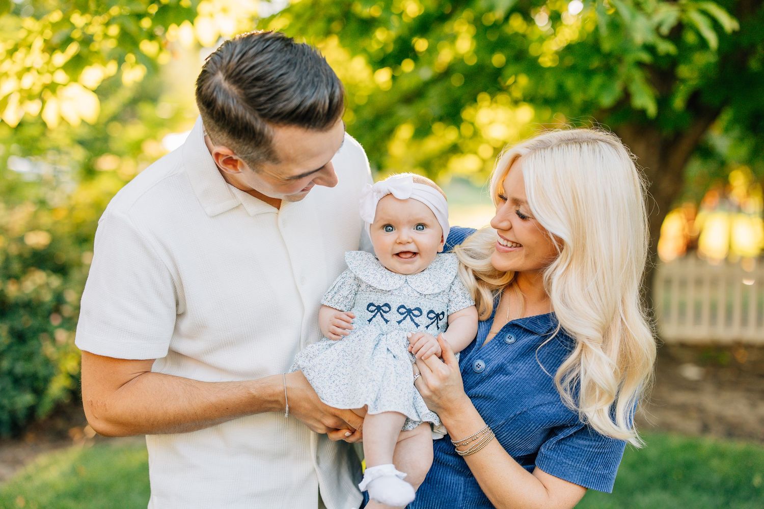 Happy family enjoying tender moments together outdoors during a golden sunset photoshoot in a garden setting. utah family photographer