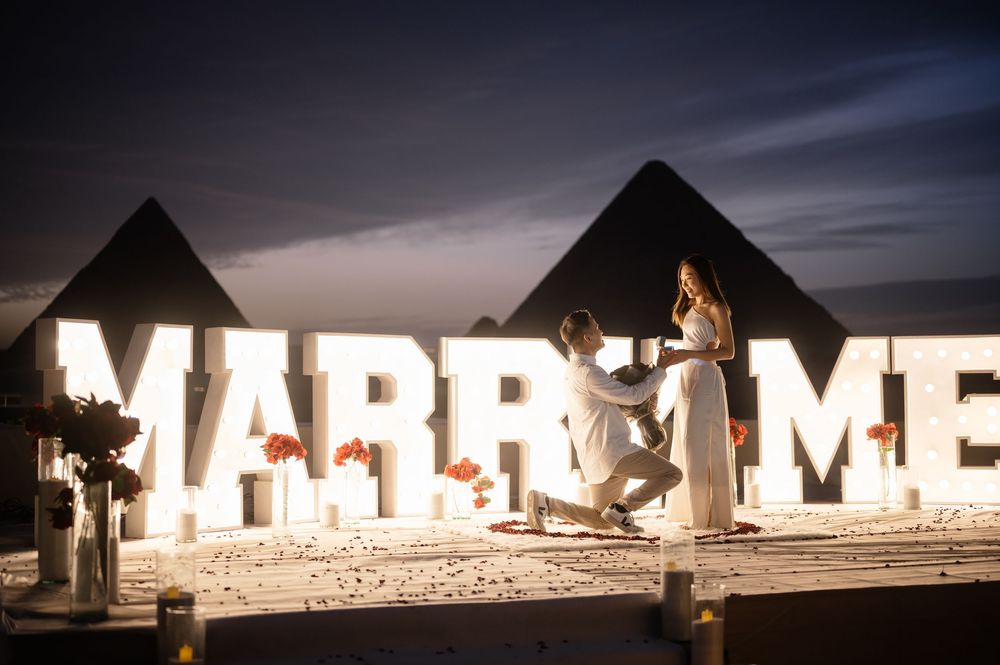Large illuminated letters spelling out 'MARRY ME' glowing against a dark background.