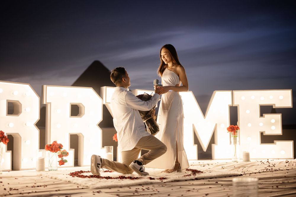 People skiing at night on snowy slopes with glowing illuminated letters creating an atmospheric winter scene.
