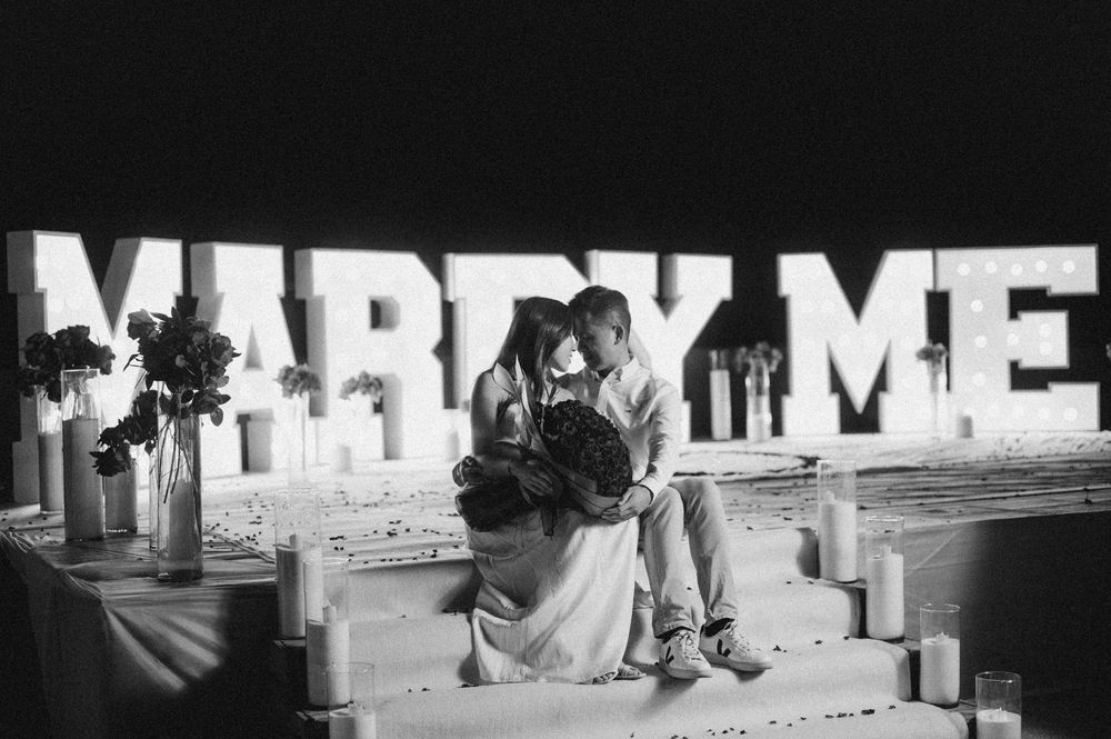 Illuminated 'MARRY ME' sign at night with soft glowing lights creating a romantic atmosphere.