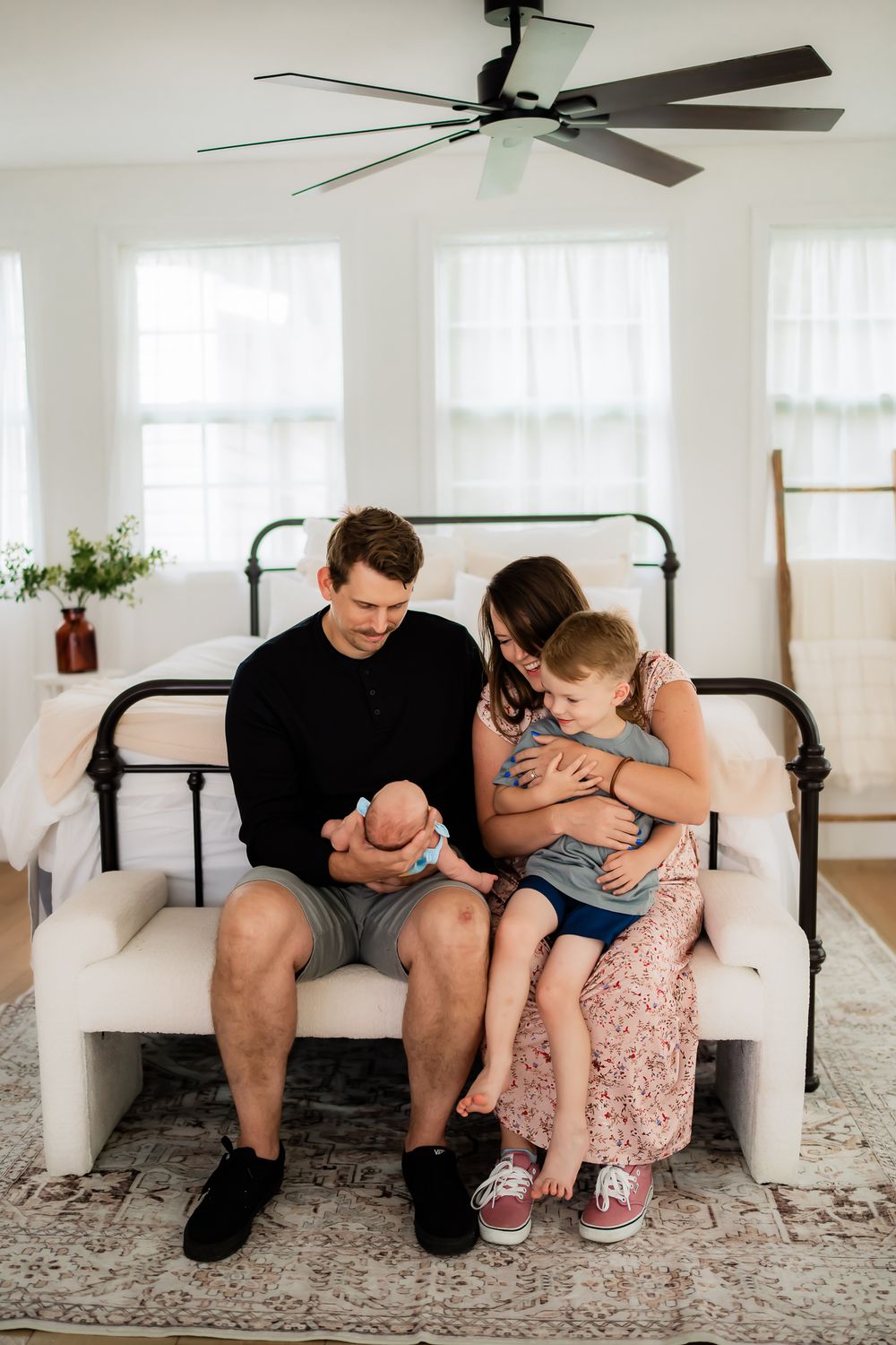 A touching emotional moment captured between two people sitting together on a white couch in a bright interior space.