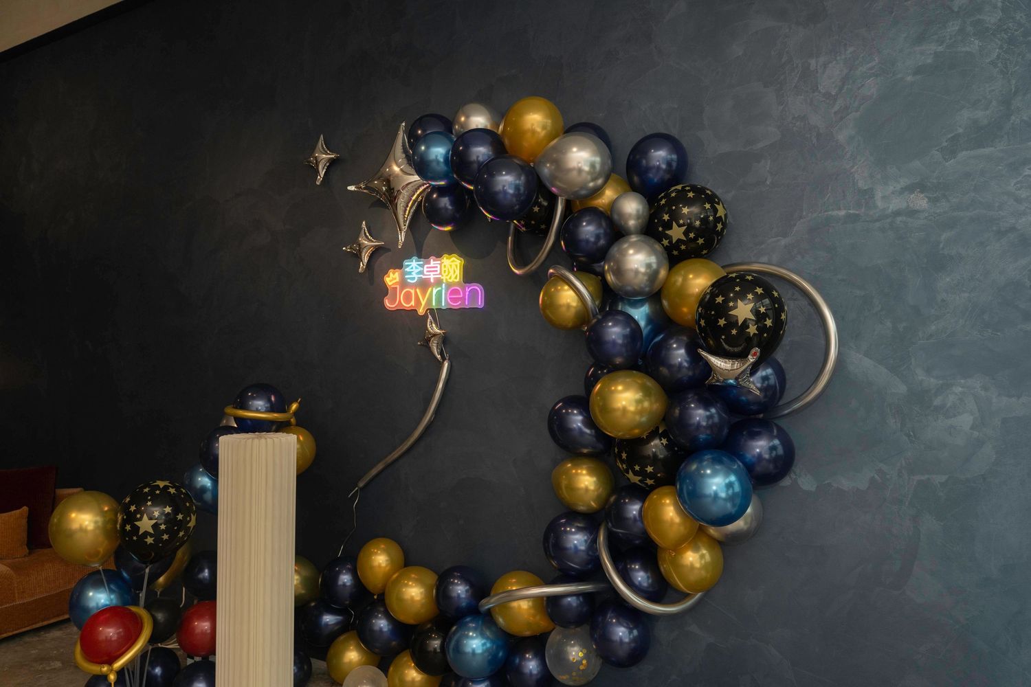 Elegant balloon arch in navy blue and gold with moons and stars creates a celestial party decoration theme.