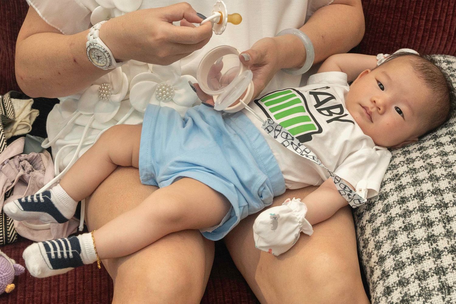 A collage shows a baby being fed and held in various tender moments throughout the day.