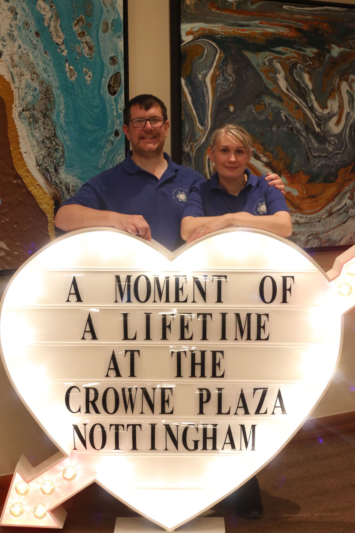 Illuminated heart-shaped signs displaying text about Crowne Plaza Nottingham.