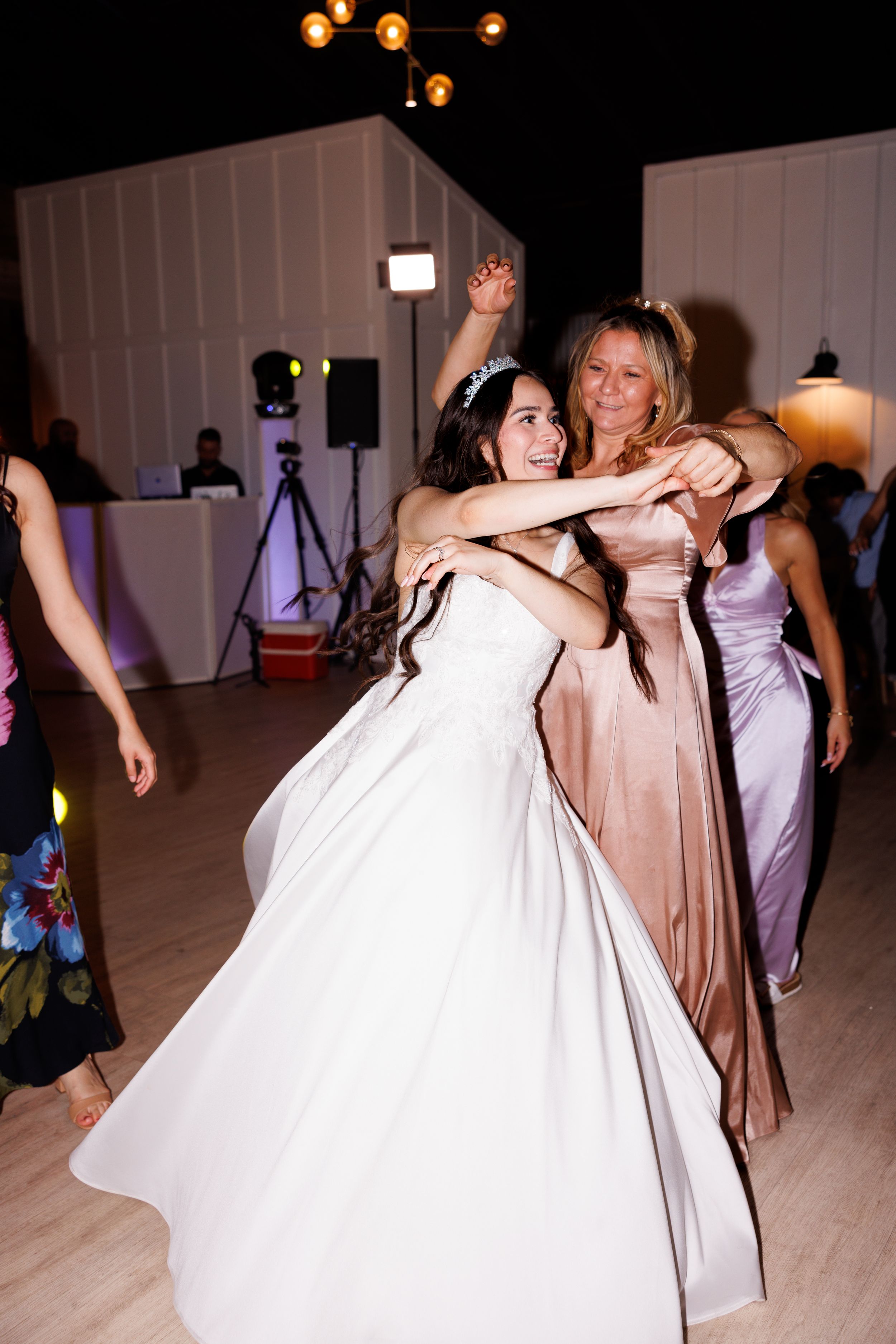 Wedding reception dance floor filled with guests in formal attire enjoying the celebration.