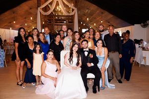 Wedding guests gather on a dance floor during a reception celebration.